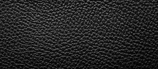 Close-up of textured black pigmented leather surface with matte finish and uniform grain pattern