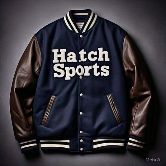 Navy letterman varsity jacket with brown leather sleeves and white "Hatch Sports" text, showcasing 2025 leather jacket trends.