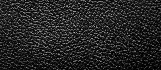 Close-up of textured black pigmented leather surface with matte finish and uniform grain pattern
