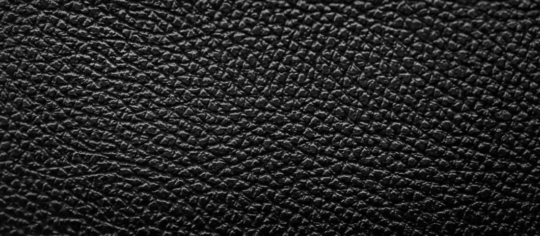 Close-up of textured black pigmented leather surface with matte finish and uniform grain pattern