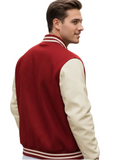A man wearing a red and cream varsity jacket, photographed outdoors on a blurred street background.